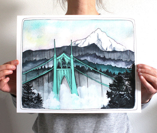 Person holding a print of the St Johns Bridge with Mt Hood in the background.