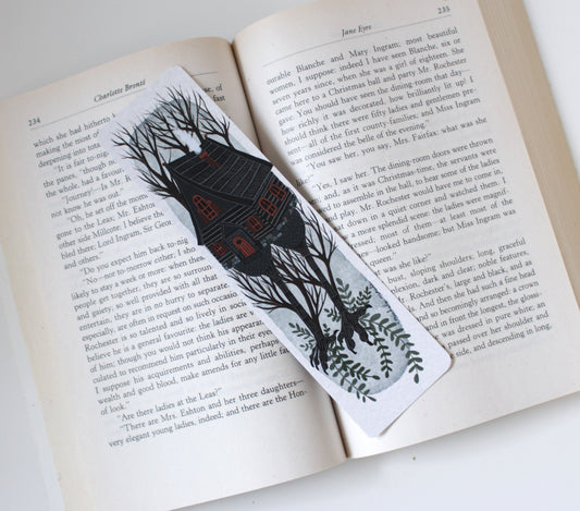 Bookmark with baba Yaga House and tree design on an open book